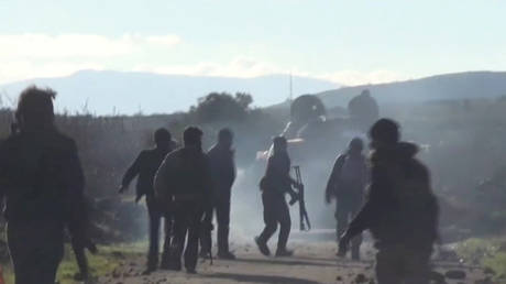 A still image taken from a video shows Syrian army soldiers walking as they advance on the town of Kfar Nabl, Syria.
