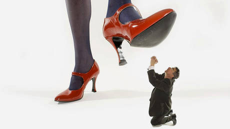 Woman in red high heels stepping on a shrunken man © Global Look Press / Rosseforp / imageBROKER.com