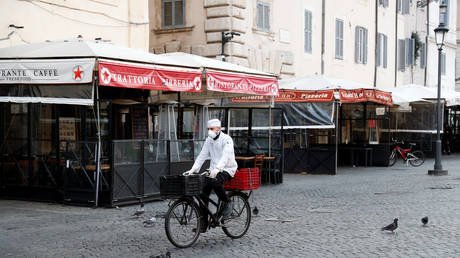 A delivery man wears a protective face mask as he rides a bicycle at Campo de Fiori, in Rome, Italy, March 10, 2020.