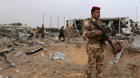 Iraqi soldiers stand guard at a Karbala airport, which was hit by US strikes, March 13, 2020