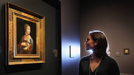 Curatorial assistant Francesca Sidhu and a painting by Leonardo da Vinci entitled 'Portrait of Cecilia Gallerani', (The Lady with an Ermine), at the National Gallery on November 07, 2011 in London, England