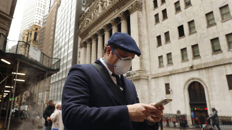 A man wears a protective mask as he walks on Wall Street during the coronavirus outbreak in New York, March 13, 2020 © Reuters / Lucas Jackson
