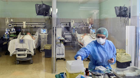 Italian medical worker wearing a protective mask and suit treats patients suffering from the coronavirus. © Reuters / Flavio Lo Scalzo