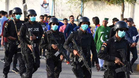 FILE PHOTO: Police officers wear masks amid coronavirus fears, as they guard Pakistan Super League cricket matches outside the National Stadium in Karachi, Pakistan.