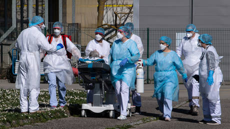 Medical staff transport a patient on a stretcher to a medical helicopter at the Emile Muller Hospital in Mulhouse, eastern France, on March 22, 2020