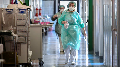 Medical workers wearing protective masks and suits walk in an intensive care unit at the Oglio Po hospital, where patients suffering from coronavirus disease (COVID-19) are treated, in Cremona, Italy March 19, 2020