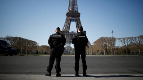 French Gendarmes patrol in front of the Eiffel tower in Paris on March 23, 2020.