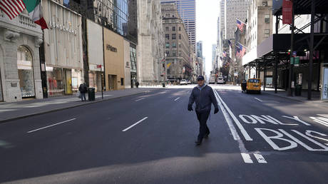 A lone man crosses 5th Ave following the outbreak of coronavirus disease (COVID-19), in the Manhattan borough of New York City, New York, U.S., March 24, 2020. © REUTERS/Carlo Allegri