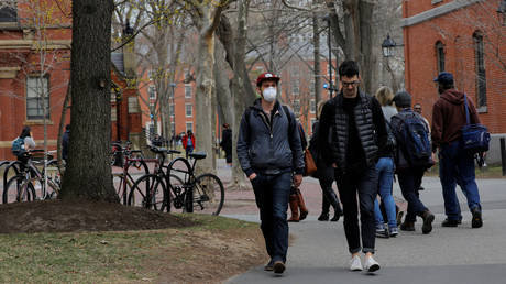 A student wearing a mask walks through the yard at Harvard University in Cambridge, Massachusetts, March 10, 2020 © Reuters / Brian Snyder