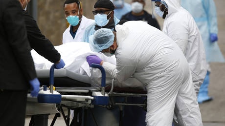 Workers wheel the body of a deceased person outside a Brooklyn hospital during the Covid-19 outbreak in New York City, March 31, 2020.
