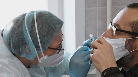 A nurse takes a swab from a suspected Covid-19 patient in Russia © Sputnik / Evgeny Epanchintsev