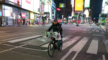 FILE PHOTO. A bicycle delivery person rides through a mostly deserted Times Square. ©REUTERS / Carlo Allegri