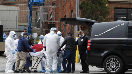 FILE PHOTO: Workers load the body of a deceased person into a hearse outside a Brooklyn hospital during the Covid-19 outbreak in New York City.