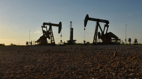 Pump jacks operate in front of a drilling rig in an oil field in Midland, Texas. © Reuters / Nick Oxford