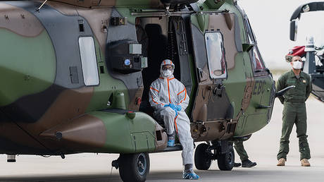 A crew member of a military transport helicopter of type NH90 (NATO Helicopter 90) sits in the door of the helicopter after landing at Dresden International Airport. © Global Look Press / Robert Michael / dpa