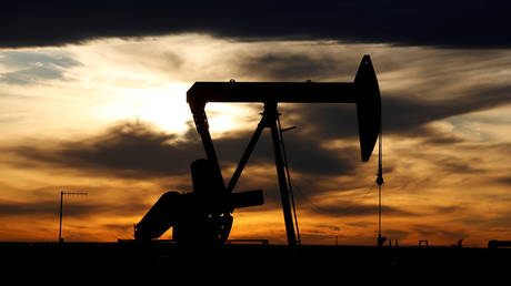 FILE PHOTO: The sun sets behind a crude oil pump jack on a drill pad in the Permian Basin in Loving County, Texas.