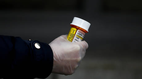 A woman in Seattle, US, holds a bottle of hydroxychloroquine tablets © Reuters / Lindsey Wasson