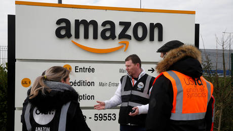 Amazon employees on strike gather outside the Amazon logistics center in Lauwin-Planque, northern France, March 19, 2020. © Reuters / Pascal Rossignol