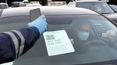 Driver shows the code of his pass to the traffic police officer at the entrance to Moscow © Sputnik / Ilya Pitalev