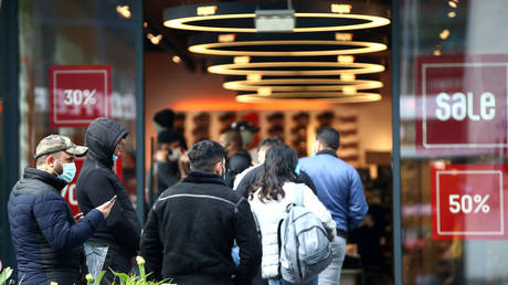 FILE PHOTO: Customers queue outside a shop as Austria's government loosens its lockdown restrictions in Vienna, Austria, on April 14, 2020.