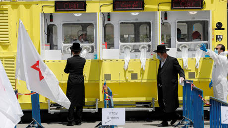 File photo: Ultra orthodox Jewish men stand by a testing station for coronavirus in Jerusalem, April 21, 2020. © REUTERS/Ammar Awad