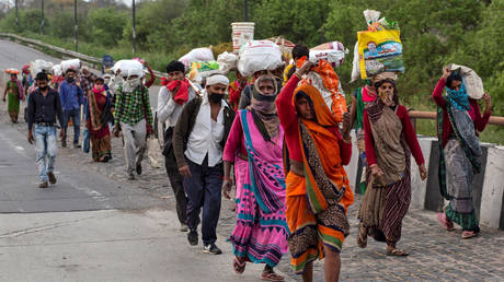 FILE PHOTO: People walk along a road to return to their villages. New Delhi, India. March © REUTERS / Danish Siddiqui