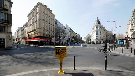 FILE PHOTO. A cyclist rides on the deserted Grands Boulevards in Paris.
