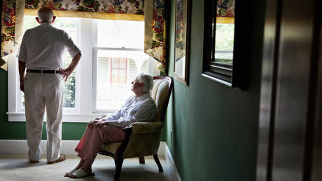 FILE PHOTO: Pensive elderly couple (80s) at home, looking out window © Getty Images / kali9