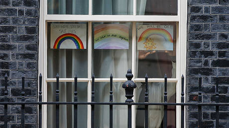 A staff member places a child's drawing in the window of 10 Downing Street ahead of the daily Coronavirus briefing on April 12, 2020 in London, England © Getty Images / Hollie Adams