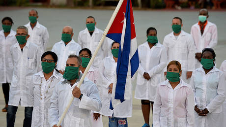 Doctors and nurses of Cuba's Henry Reeve International Medical Brigade take part in a farewell ceremony before traveling to Andorra to help in the fight against the coronavirus COVID-19 pandemic, at the Central Unit of Medical Cooperation in Havana, on March 28, 2020. © AFP / YAMIL LAGE