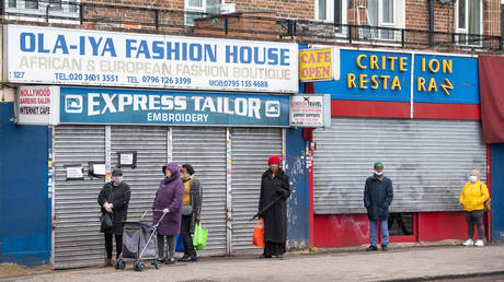 People observe social distancing as they queue for a branch of the post office, in south London © Getty Images / PA Images / Dominic Lipinski