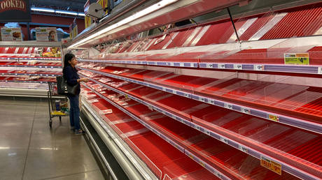 FILE PHOTO: A shopper picks over the few items remaining in the meat section at an Austin, Texas, grocery store on March 13, © Reuters / Brad Brooks