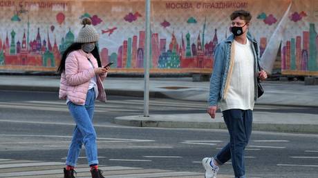 People wearing protective masks walk during mandatory self-isolation due to coronavirus disease outbreak, in Moscow, Russia. © Sputnik / Evgeny Biyatov