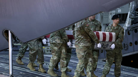 An honor guard carries the transfer case holding the remains of a US soldier killed in Afghanistan, at Dover Air Force Base, in Dover, Delaware. February 2020. © Reuters / Jonathan Ernst