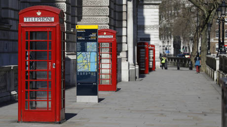 Empty telephone boxes are seen in a near deserted central London, UK. © AFP / Tolga Akmen