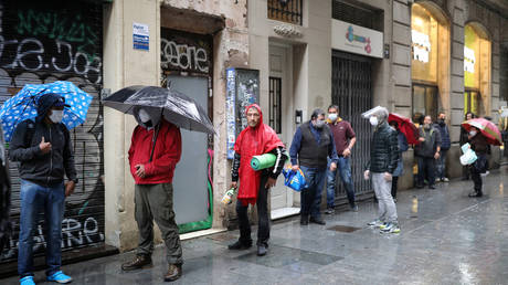 People wait for free food packages outside parish church of Santa Anna, Barcelona, Spain, April 21, 2020 © Reuters / Nacho Doce