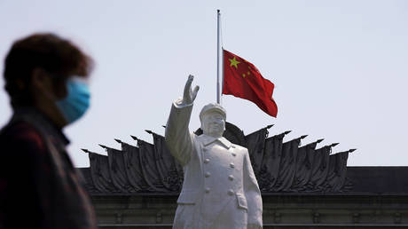 FILE PHOTO: The Chinese national flag behind a statue of Mao Zedong in Wuhan, Hubei province, April 4, 2020. © Reuters / Aly Song
