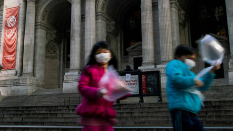 FILE PHOTO: Children wearing face masks to protect from the coronavirus pass in front of the shuttered New York Public Library.