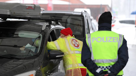 A medic checks the temperature of a driver coming from Italy at the Brenner Pass, March 10, 2020