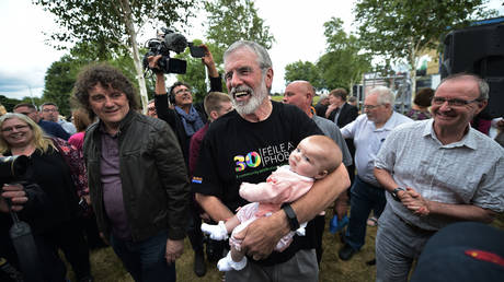 Gerry Adams with a supporter's baby at a rally called in support of the former Sinn Fein President on July 16, 2018 in Belfast, Northern Ireland