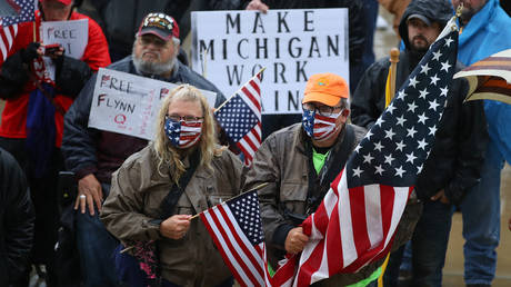 Protesters holding American flags gather at the Michigan Capitol Building on May 14, 2020 in Lansing, Michigan. © Getty Images / Gregory Shamus