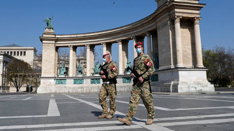 Military police officers patrol the deserted Heroes' Square as the spread of coronavirus disease continues in Budapest. © Reuters / Bernadett Szabo
