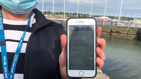 NHS employee shows a smartphone displaying the new NHS Covid-19 tracing app being trialled on the Isle of Wight © REUTERS / Isla Binnie