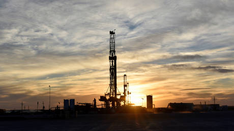 FILE PHOTO: Drilling rigs operate at sunset in Midland, Texas, US.