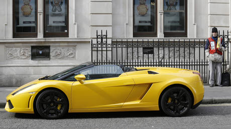 A man sells copies of the "Big Issue" next to a Lamborghini car in Covent Garden in central London © REUTERS/Luke MacGregor