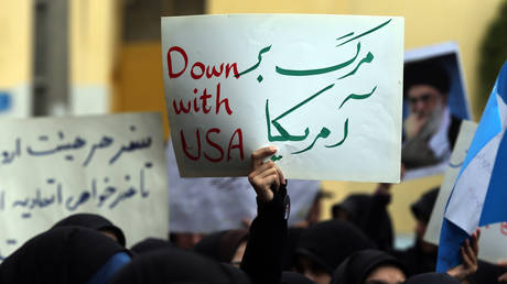 FILE PHOTO: An Iranian protester holds a placard reading "down with USA" during a demonstration in Tehran, Iran. April 8, 2014 © AFP / Atta Kenare