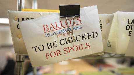 Mailed in ballots sit in US Postal Service bins inside the office of the Stanislaus County Clerk