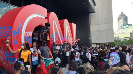 A man raises his fist on top of the CNN logo in front of the CNN Center during a protest against the death George Floyd, Atlanta, Georgia, US, May 29, 2020