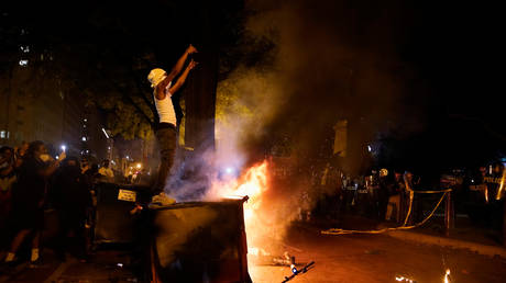 Demonstrators gesture next to a fire during a rally near the White House against the death in Minneapolis police custody of George Floyd in Washington, DC, May 30, 2020