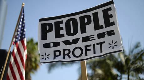 A protestor holds a sign during a march and rally by Walmart employees and union members calling for higher wages and better jobs in Los Angeles